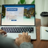 Online booking platform on a laptop computer by a person. Man use websites to search for accommodation, hotels and airlines for their vacation trips or buy tours on the Internet.